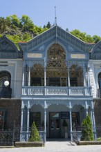 Historic blue veranda with ornate decorations and ornaments under bright sun, old villa of