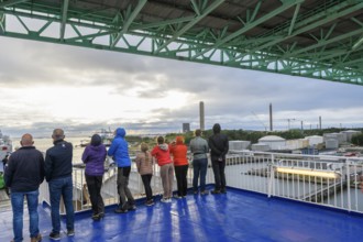 Group of people on a ship deck looking at the harbor crossing under the Älvsborgsbron suspension