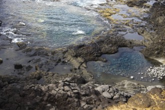 Rocky landscape with cliffs and natural pools with clear water on a rough, wave-driven coast, Yaiza