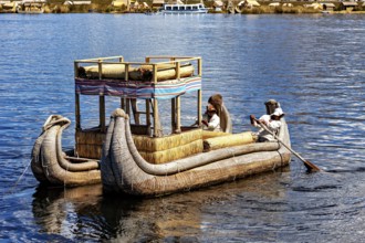People on a large reed boat on a lake, dressed traditionally, The floating reed islands of the Uros