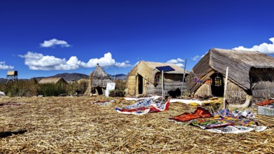 Traditional thatched huts on an island under a clear sky, The floating reed islands of the Uros in