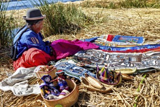 Woman sitting at colorful crafts on an island near a lake, The floating reed islands of Uros in