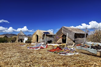 Straw huts on an island with traditional handmade objects in the foreground, The floating reed