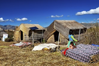 Woman approaches huts made of reeds, dressed in traditional clothing, The floating reed islands of