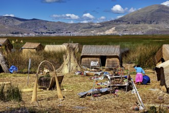 Reed huts with mountains in the background and scattered crafts, The floating reed islands of the