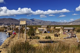 A traditional village with reed huts and views of mountains under cloudy skies, The floating reed