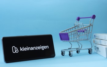 Dhaka, Bangladesh- 03 July 2025: Smartphone with Kleinanzeigen logo next to a small shopping cart