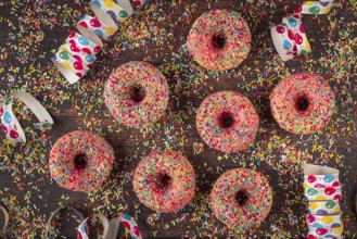 Donuts with colorful sprinkles and confetti on table, carnival