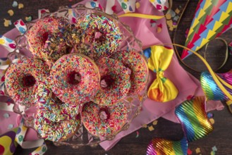Colourful donuts with party decorations such as streamers, bow and confetti, carnival