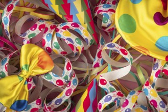 Colourful streamers with party hats and a yellow bow on a cheerful background, Mardi Gras