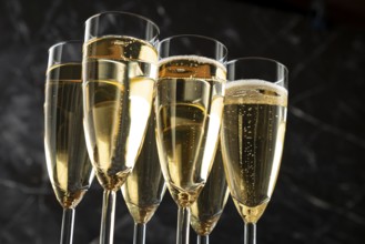 Champagne glasses with sparkling content against a black background