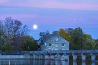 Illuminated Moulin Neuf water flow control dam and walkway over Des Mille-Iles river plus New Mill