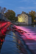 Illuminated Moulin Neuf water flow control dam and walkway over Des Mille-Iles river plus New Mill