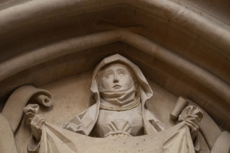 Woman in medieval clothing holding cloth with the face of Christ, stone figure, choir room,
