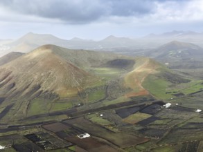 View of Montaña Tesa volcano from Montaña Blanca mountain with cloudy sky, Lanzarote, Canary