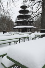 Winter in the English Garden, snow-covered beer garden tables and benches, Chinese Tower, Munich,
