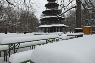 Winter in the English Garden, snow-covered beer garden tables and benches, Chinese Tower, Munich,