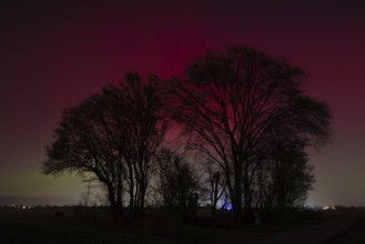 Northern lights (aurora borealis) glow red and green in the evening sky over Germany, Frankfurt am