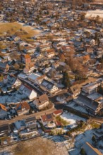 Bird's-eye view of city with snow-covered roofs in winter at sunset, Hallwangen, Freudenstadt