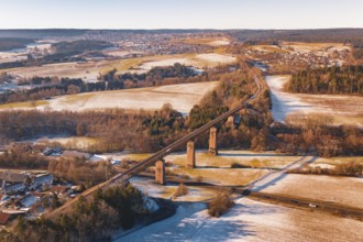 Winter landscape with a railroad bridge across fields and snow-covered hills, Dornstetten,