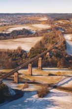 Railway bridge in winter surrounded by snow-covered fields and roads, Dornstetten, Freudenstadt