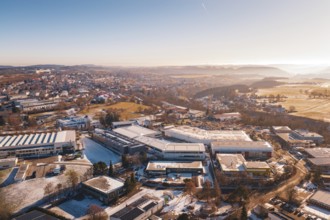 Aerial view of a wintery cityscape with buildings and fields in morning light, Dornstetten,