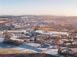 City view in winter with snow-covered fields and buildings under a foggy sky, Dornstetten,
