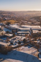 Industrial landscape in winter with buildings under clear sky in soft sunlight, Dornstetten,