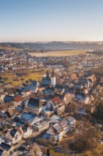 City view from the air with church architecture, surrounded by red roofs, in a winter landscape,
