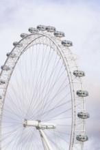 A majestic Ferris wheel dominates the cloudy sky with its capsules, London Eye, London, United