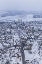 Snowy city landscape with houses and fields under a grey sky, Empfingen, Freudenstadt district,