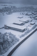 Aerial view of a snowy factory and road with surrounding trees, Hörschweiler, Freudenstadt