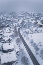 Snowy village with snow-covered houses and roads under cloudy sky, Schopfloch, Freudenstadt