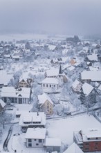 Wintery village with snow-covered roofs and a church in the center, Schopfloch, Freudenstadt