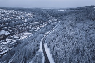Snowy road between thick forests, wintry driving experience, Altensteig, Calw district, Germany