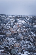 Snowy town with half-timbered houses and church, surrounded by winter landscape, Altensteig, Calw