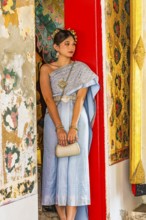 Young woman in traditional clothing presents herself to photographers, Wat Arun Buddhist temple,