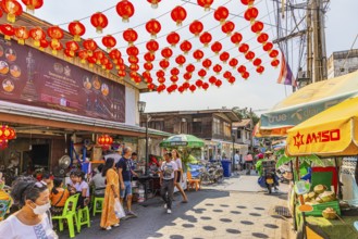 Busy access road covered with red lanterns, to Wat Arun Buddhist temple, Bangkok, metropolis of
