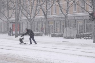 Senior with walker during heavy snowfall, winter, Germany