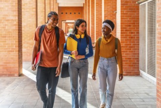 Diverse students walking through a university building on campus, carrying backpacks and notepads,