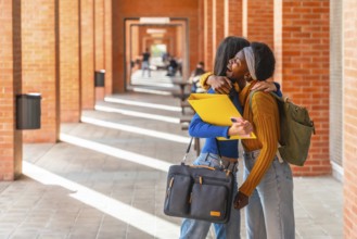 Joyful multiracial students are sharing a warm hug on a university campus, celebrating their