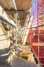 A scaffolding with wooden panels and casting shadows on a construction site, carpentry