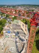Crane rising high above a construction site with urban landscape in the background, construction