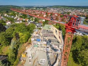 Large crane over a construction site with city panorama in the background, construction site of a