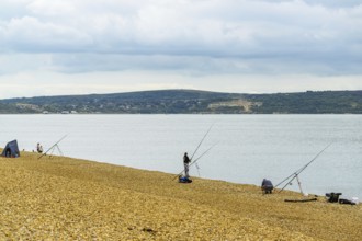 Anglers on the beach over Hurst Spit, Milford on Sea, Lymington, Hampshire, England, United Kingdom