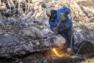 Workers with cutting torches demolishing the 120-meter long motorway bridge of the A516, across