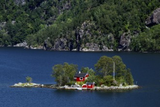 Small island in Lovrafjord with a red house surrounded by blue waters, Lovrafjord, Ryfylke, Norway