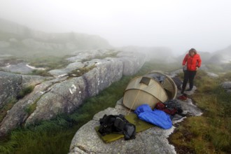 Tent fighting on rocky terrain in foggy conditions near Prekestolen