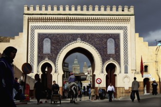 The decorative Bab Boujeloud city gate in Fez with pedestrians and distinctive architecture, Fez,