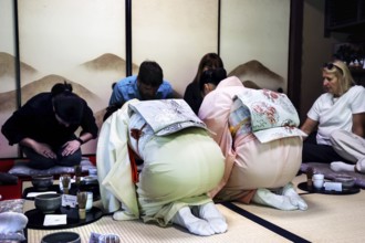 Attendees bow during the tea ceremony in a traditional room, Kyoto, Higashiyama, Japan